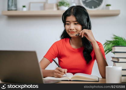 working woman reading a book on the table and wearing headphones