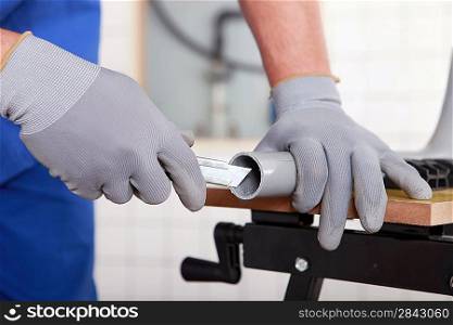 workman cutting plastic pipe