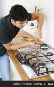 Workman Installing Gas Cooker In New Kitchen