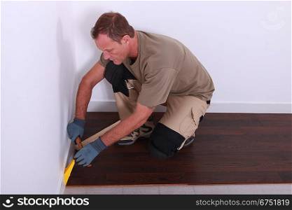 Workman installing laminate floor