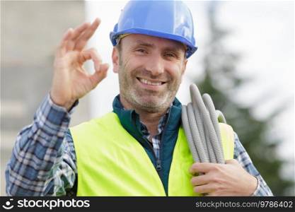 workman making ok sign on unfocused background