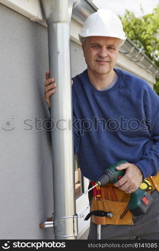 Workman Replacing Guttering On Exterior Of House