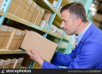 Workman selecting box from shelf