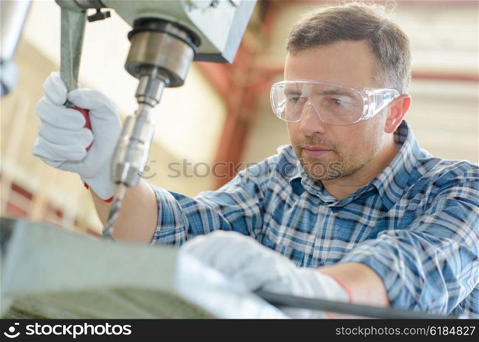 Workman using bench drill