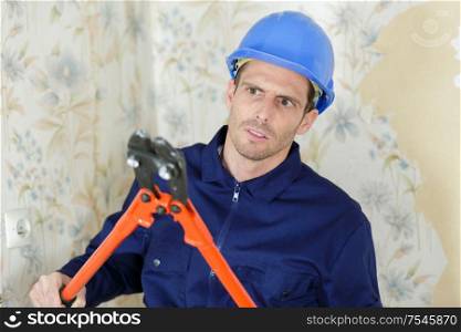 workman with scissors mower indoors