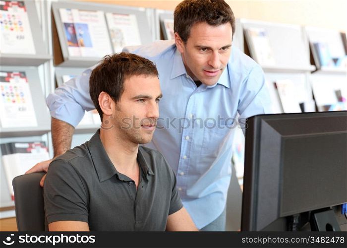 Workmates in office in front of desktop