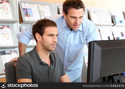 Workmates in office in front of desktop
