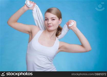 Workout, hygiene concept. Smiling woman holding a towel above her head smiling, studio shot on blue background. Woman with a towel above her head
