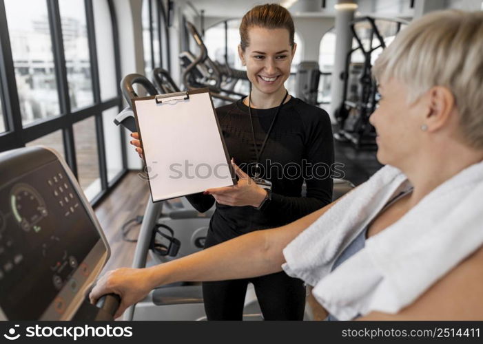 workout program trainer client showing clipboard