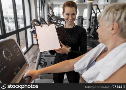 workout program trainer client showing clipboard