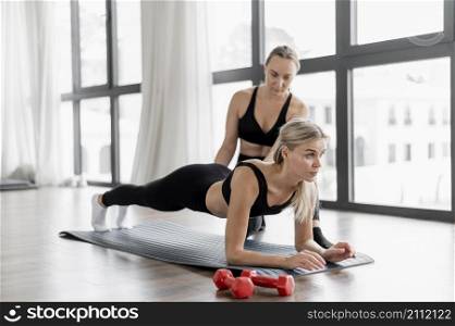 workout with personal trainer doing low plank