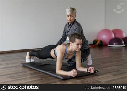 workout with personal trainer doing low plank high view
