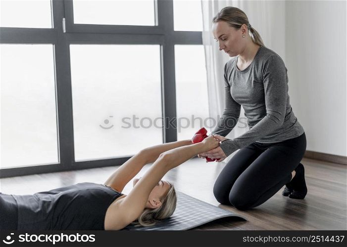 workout with personal trainer laying yoga mat