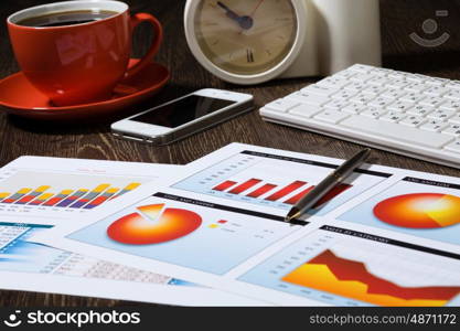 Workplace at office. Workplace with keyboard cup of coffee and graphs