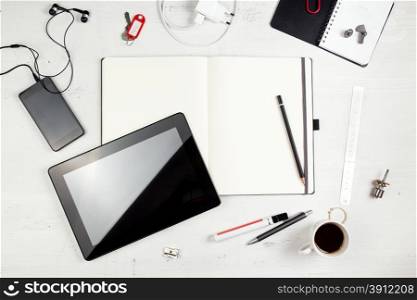 Workplace. Empty notepad, tablet pc and smart phone on white wooden table