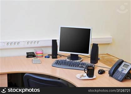 Workplace in office with monitor and cup on work table