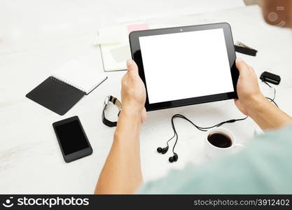 Workplace. Man working on tablet pc, notepad and smart phone on white wooden table