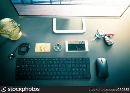 Workplace of a freelancer: Arrangement of computer, keyboard, credit card, compass, keys and globe