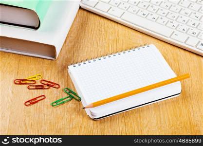 Workplace. Stationary supplies and keyboard on wooden table