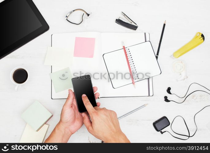 Workplace. Top view. Man working with modern devices and writing on notebook