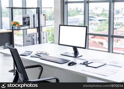 Workspace Business mockup desktop computer empty white screen with keyboard notebook and other accessories on Modern dark wooden office corner and black office chairs with window in office interior
