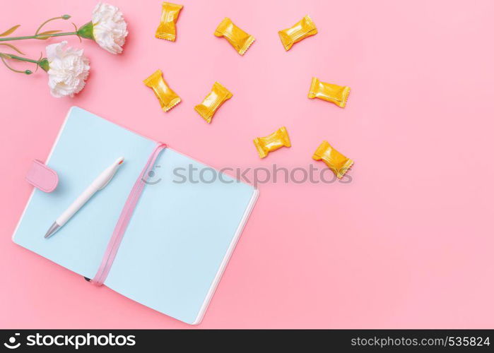 workspace desk styled design office supplies, candy and flower on pink pastel background minimal style