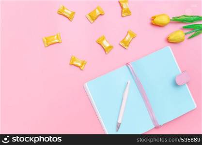 workspace desk styled design office supplies, candy and flower on pink pastel background minimal style