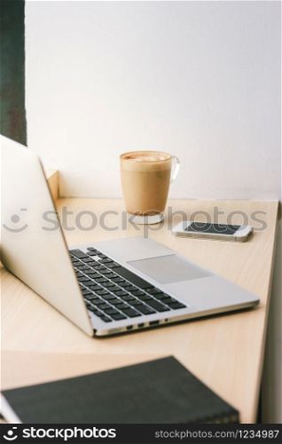 Workspace in the cafe with computer laptop and latte coffee and smartphone, lifestyle and business concept