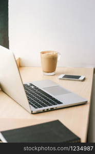 Workspace in the cafe with computer laptop and latte coffee and smartphone, lifestyle and business concept