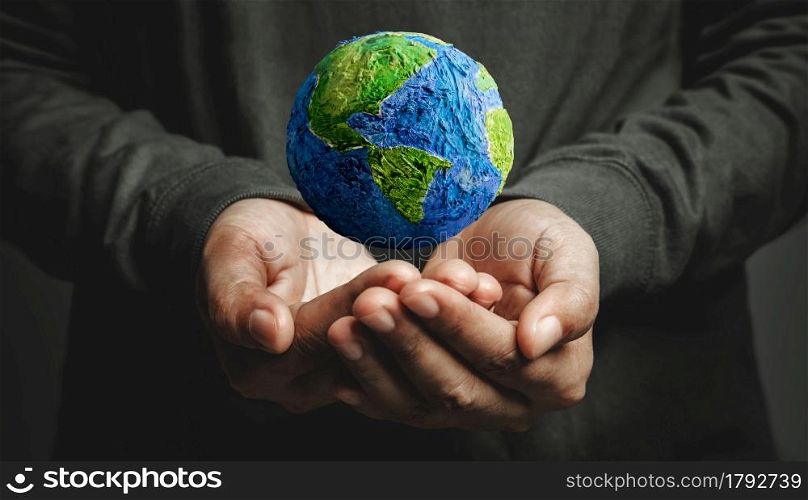 World Earth Day Concept. Green Energy, Renewable and Sustainable Resources. Environmental and Ecology Care. Hand Levitating a Green Handmade Globe