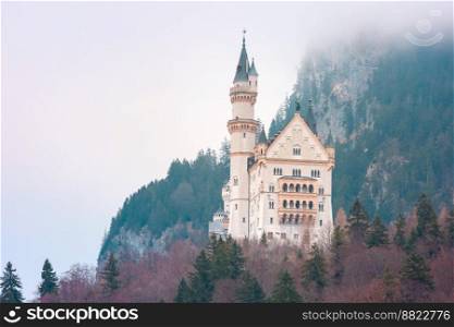 World-famous tourist attraction in the Bavarian Alps, fairytale Neuschwanstein or New Swanstone Castle, the 19th century Romanesque Revival palace in the foggy day, Hohenschwangau, Bavaria, Germany. Fairytale Neuschwanstein Castle, Bavaria, Germany