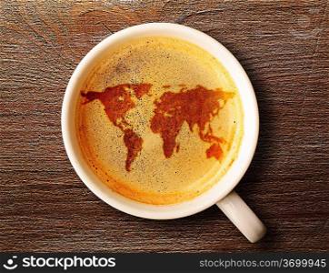 world map on cup of fresh espresso on table, view from above