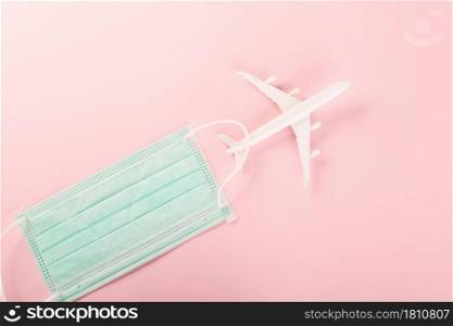 World Tourism Day, Top view model plane and medical face mask, Holiday accessory beach trip travel vacation studio shot isolated pink background with copy space