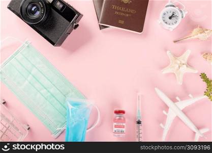 World Tourism Day, Top view model plane, medical face mask, coronavirus vaccine and vintage camera, Holiday accessory beach trip travel vacation studio shot isolated pink background with copy space