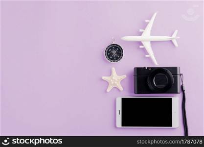 World Tourism Day, Top view of minimal model plane, airplane, starfish, alarm clock, compass and smartphone blank screen, studio shot isolated on purple background, accessory flight holiday concept