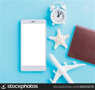 World Tourism Day, Top view of minimal model plane, airplane, starfish, alarm clock, compass and smartphone blank screen, studio shot isolated on blue background, accessory flight holiday concept