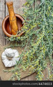 wormwood and mortar. Branch of medicinal sage and mortar with pestle