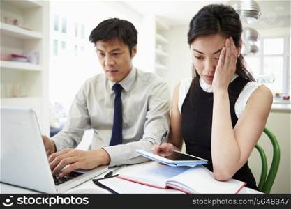 Worried Asian Couple Looking At Personal Finances