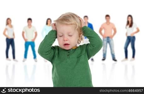 Worried blonde baby with people unfocused background