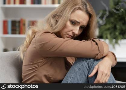 worried blonde woman sitting couch
