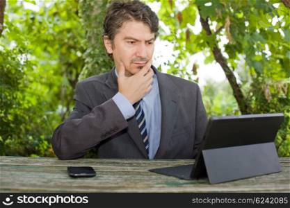 worried businessman with digital tablet, outdoors