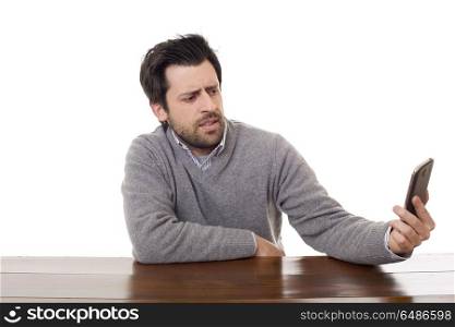 worried casual man with a phone, on a desk, isolated. on the phone