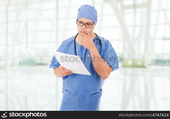 worried doctor looking to his notes, at the hospital