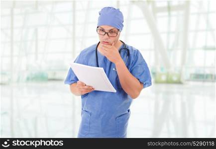 worried doctor looking to his notes at the hospital