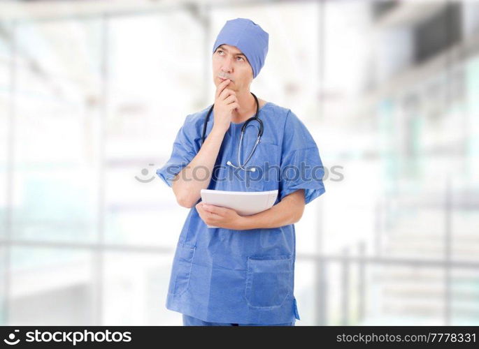 worried doctor looking to his notes, at the hospital