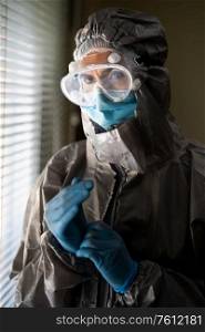 Worried Doctor or lab technician scientist in PPE Personal Protective Equipment near a hospital window. Female Doctor in PPE Personal Protective Equipment