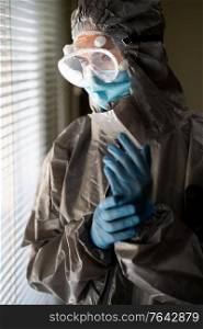 Worried Doctor or lab technician scientist in PPE Personal Protective Equipment near a hospital window. Female Doctor in PPE Personal Protective Equipment