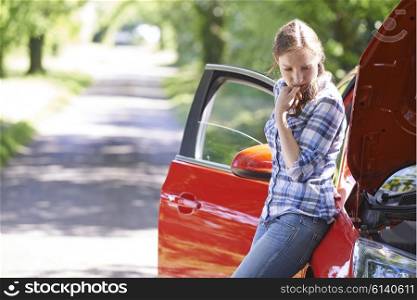 Worried Female Motorist Standing Next To Broken Down Car