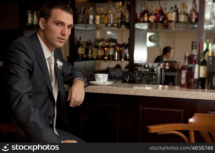 Worried man sitting at bar with tea cup