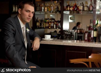 Worried man sitting at bar with tea cup